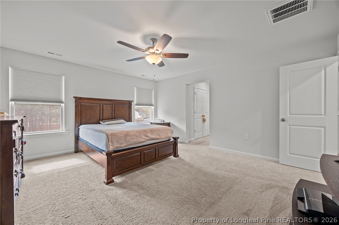 334 Beacon Hl Road Lillington, NC 27546 - Photo 21 of 49 a bedroom with a bed and a chandelier
