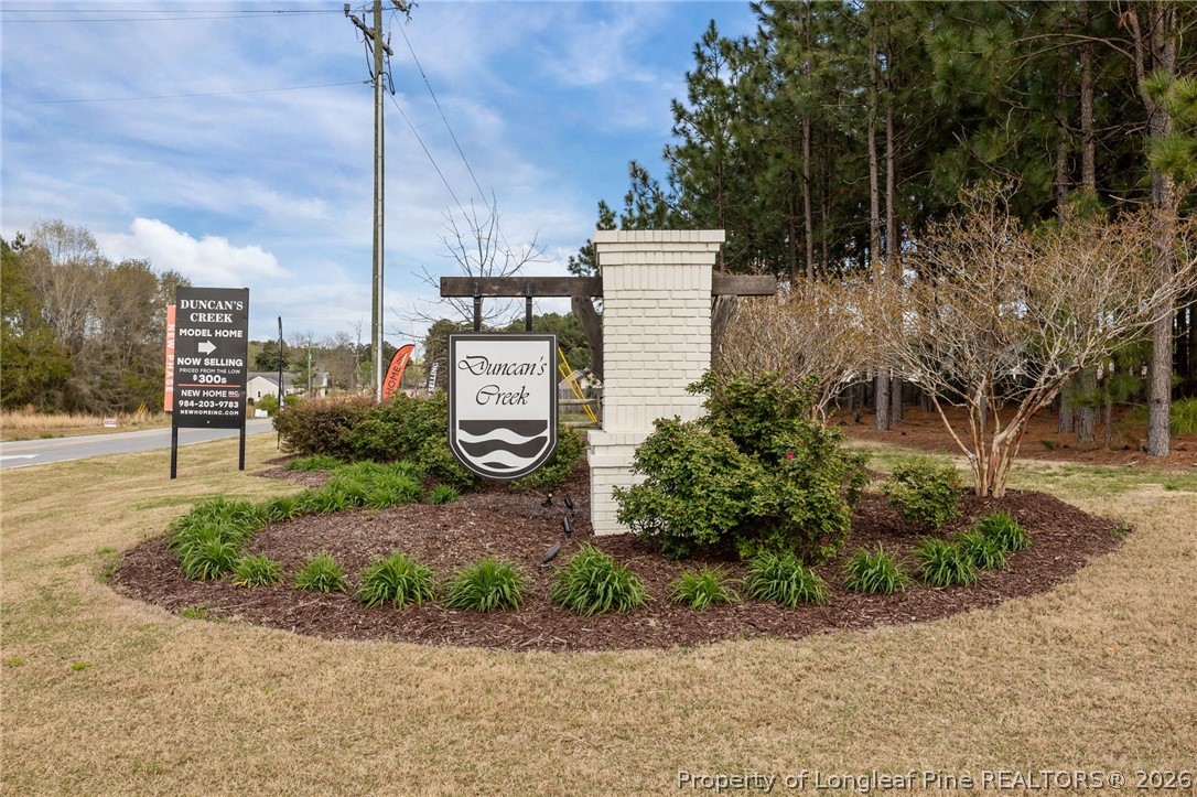 334 Beacon Hl Road Lillington, NC 27546 - Photo 49 of 49 a sign board with flower plants and wooden fence