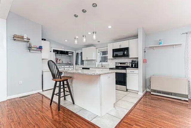 a kitchen with cabinets and wooden floor