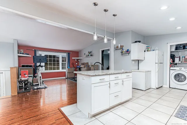 a large kitchen with kitchen island a counter space a sink and appliances