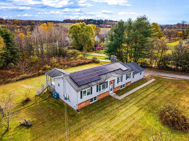 a aerial view of a house with swimming pool and large trees
