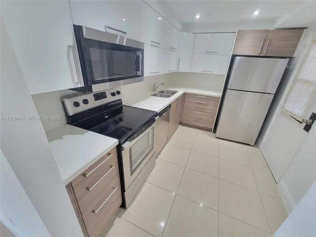 a kitchen with stainless steel appliances a stove a sink and a refrigerator