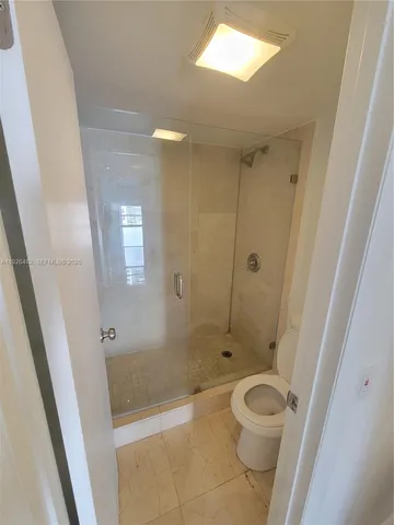 a bathroom with a shower a toilet and a sink