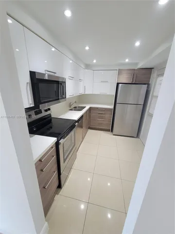 a kitchen with a sink a stove a microwave and a refrigerator