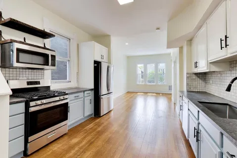 a kitchen with stainless steel appliances kitchen island granite countertop a stove a refrigerator and a microwave