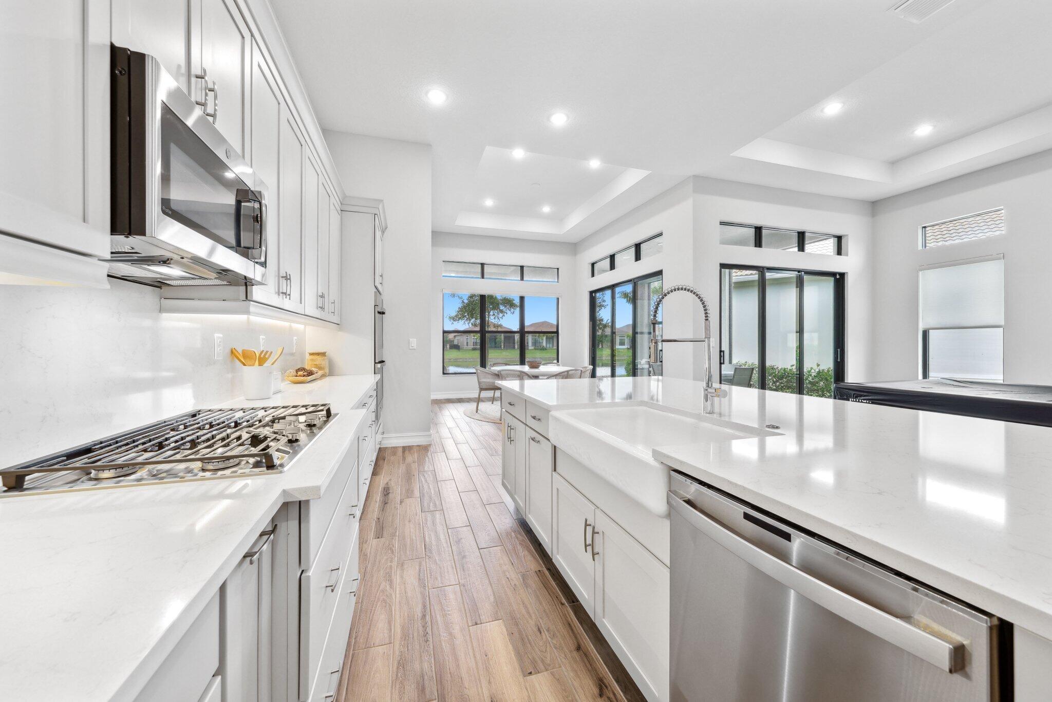 11786 Vivar Run Parkland, FL 33076 - Photo 11 of 46 a large kitchen with stainless steel appliances granite countertop a lot of counter space and wooden floors