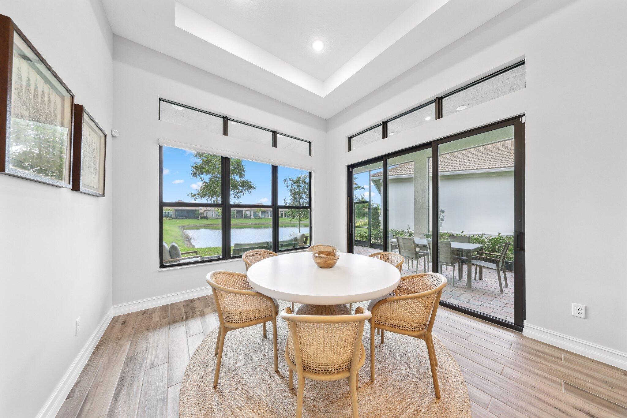 11786 Vivar Run Parkland, FL 33076 - Photo 14 of 46 a dining room with furniture a chandelier and wooden floor