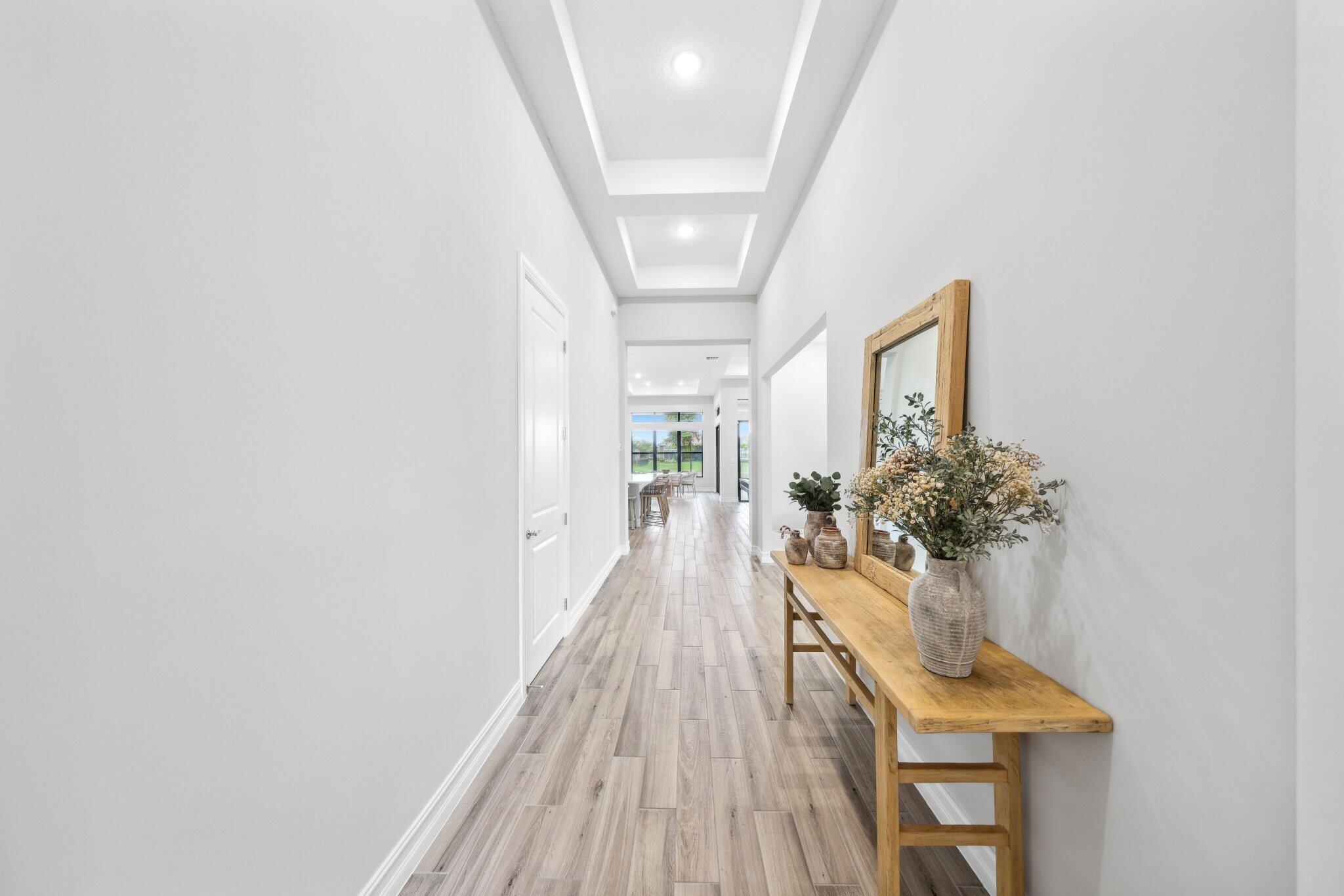 11786 Vivar Run Parkland, FL 33076 - Photo 3 of 46 a view of a hallway with wooden floor and a potted plant