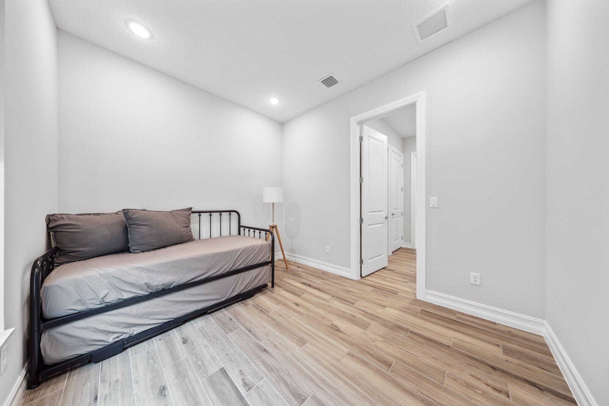 11786 Vivar Run Parkland, FL 33076 - Photo 37 of 46 a spacious bedroom with a bed and a wooden floor