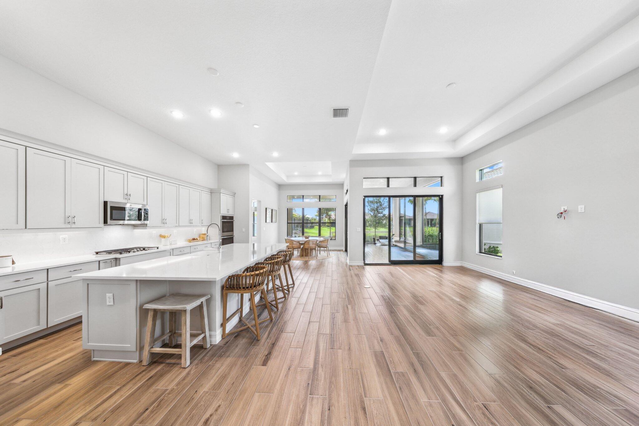 11786 Vivar Run Parkland, FL 33076 - Photo 4 of 46 a kitchen with stainless steel appliances granite countertop a lot of counter space and wooden floors