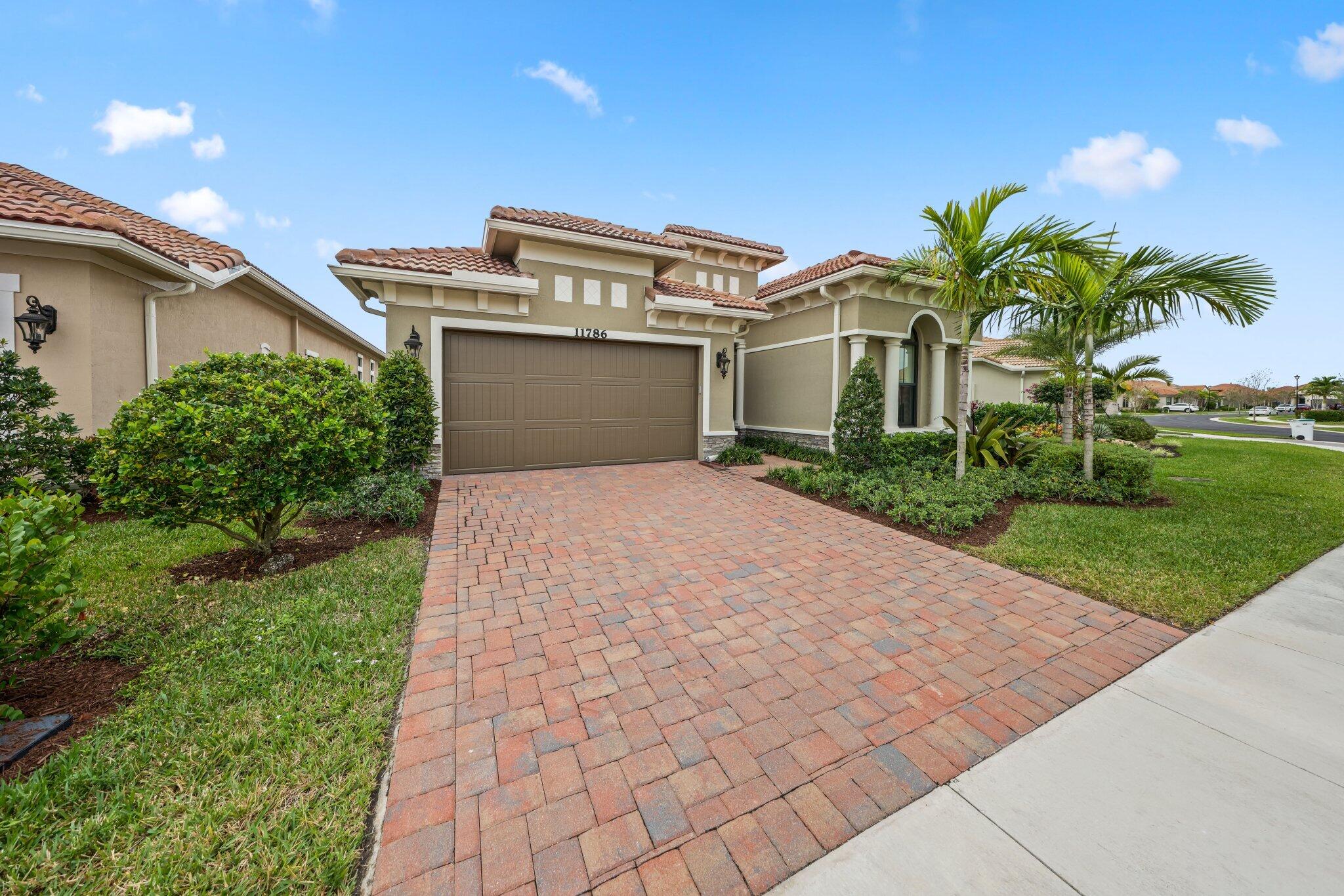 11786 Vivar Run Parkland, FL 33076 - Photo 41 of 46 a front view of a house with a yard and potted plants