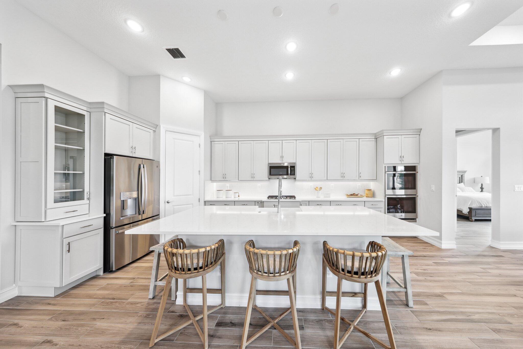 11786 Vivar Run Parkland, FL 33076 - Photo 7 of 46 a kitchen with refrigerator cabinets dining table and chairs