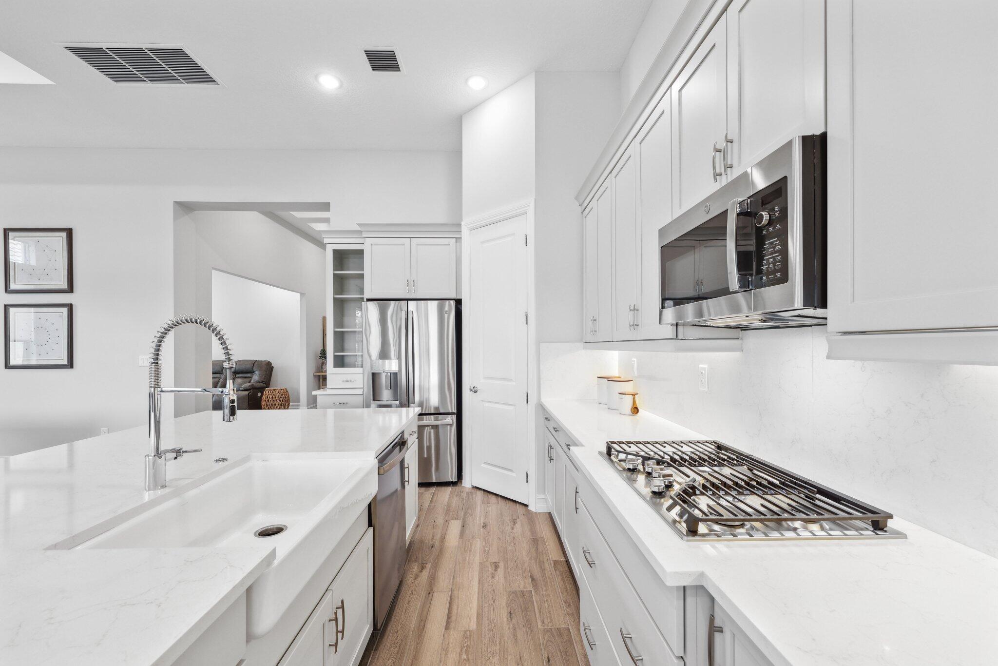 11786 Vivar Run Parkland, FL 33076 - Photo 10 of 46 a kitchen with stainless steel appliances a sink stove and microwave