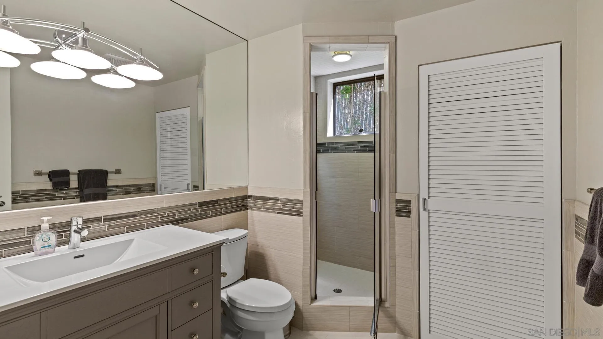 7778 Starlight Drive La Jolla, CA 92037 - Photo 26 of 36 a bathroom with a toilet a sink a mirror and vanity