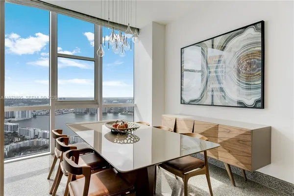 a dining room with furniture a chandelier and wooden floor