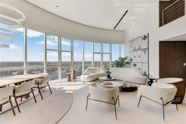 a living room with furniture and large windows