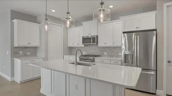 a kitchen with stainless steel appliances granite countertop a refrigerator a sink and a oven