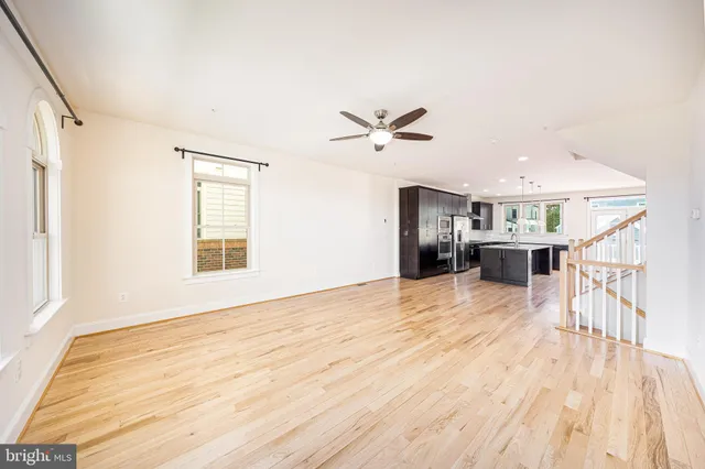 a large kitchen with stainless steel appliances kitchen island a large counter top and a wooden floors