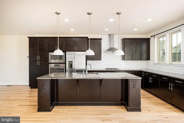 a kitchen with stainless steel appliances kitchen island granite countertop a stove microwave and refrigerator