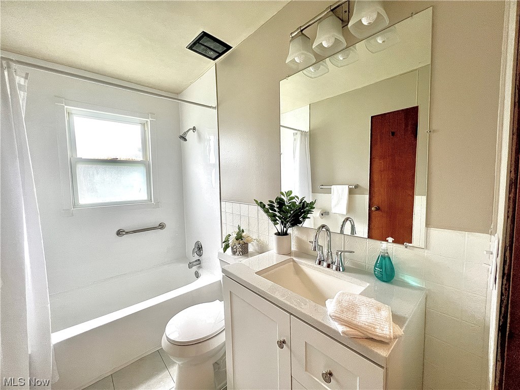 3923 Jaeger Road Lorain, OH 44053 - Photo 8 of 34 Full main bathroom featuring mirror, shower / bath combo, tile flooring, vanity, and tile walls