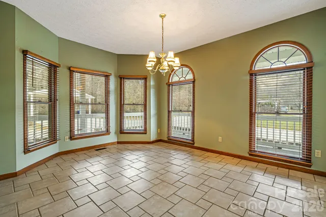 a view of an empty room with window chandelier