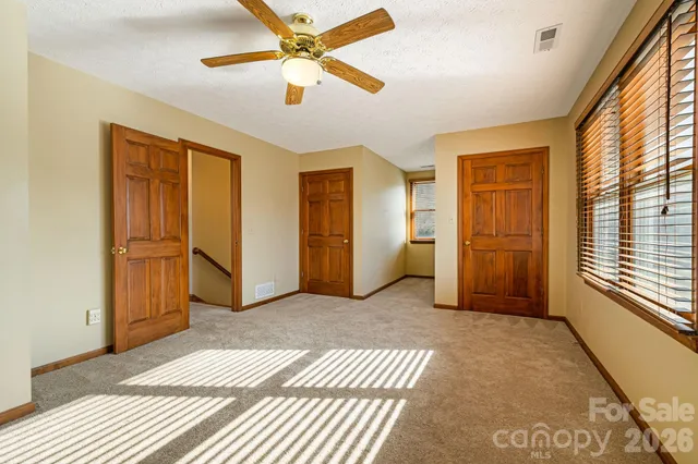 a view of a livingroom with wooden floor and a ceiling fan