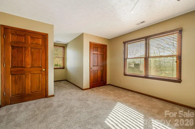 an empty room with windows and closet