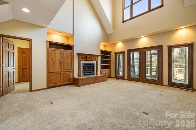 a view of an empty room with a fireplace and a window