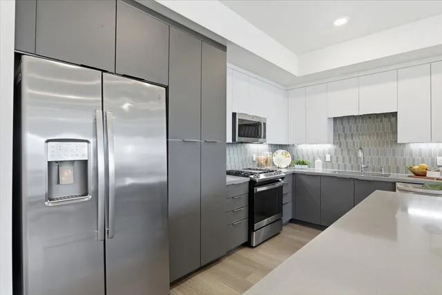 a kitchen with stainless steel appliances granite countertop a kitchen island hardwood floor sink stove dining table and chairs