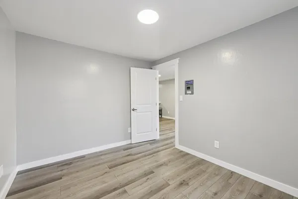 an empty room with wooden floor and white walls