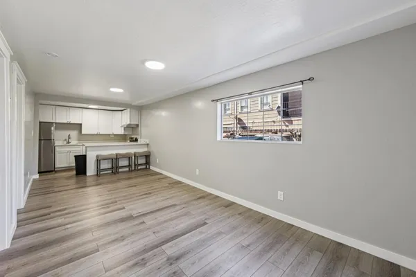 a living room with stainless steel appliances kitchen island wooden floors and view kitchen