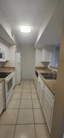 a kitchen with a stove top oven and cabinets