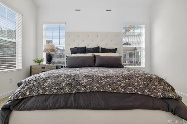 a bedroom with a large bed and wooden floor