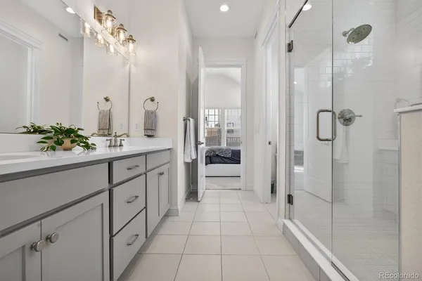 a bathroom with a double vanity sink a large mirror and shower