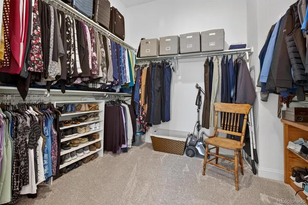 a view of walk in closet with clothes and shoes