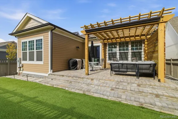 a view of house with backyard and sitting area