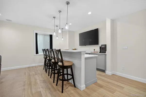 a large kitchen with a large counter top a sink stainless steel appliances and cabinets