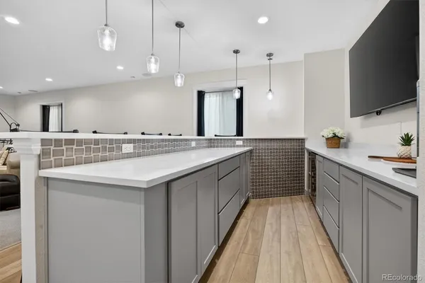 a living room with stainless steel appliances kitchen island granite countertop a sink and a microwave