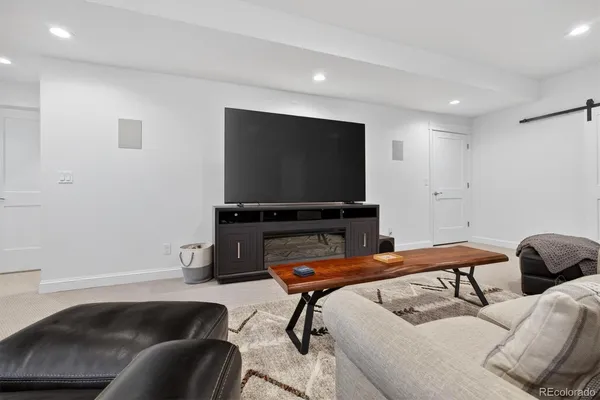 a living room with furniture and a view of kitchen