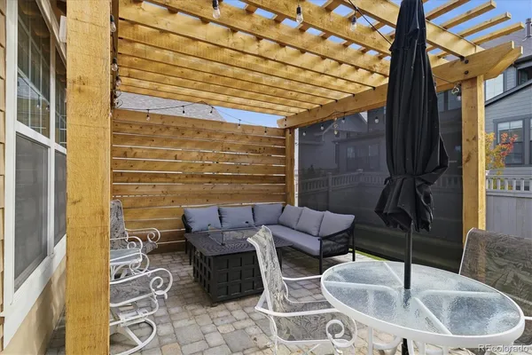 a view of a white house with a small yard plants and large tree