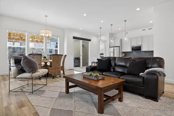 a living room with furniture a dining table and a chandelier