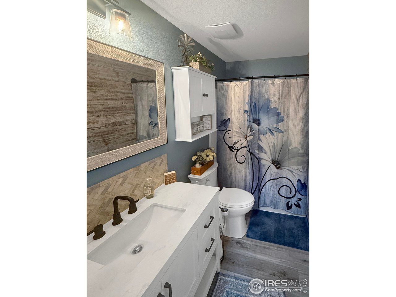 14971 Bluestem Street Sterling, CO 80751 - Photo 20 of 33 a bathroom with a sink and mirror with toilet