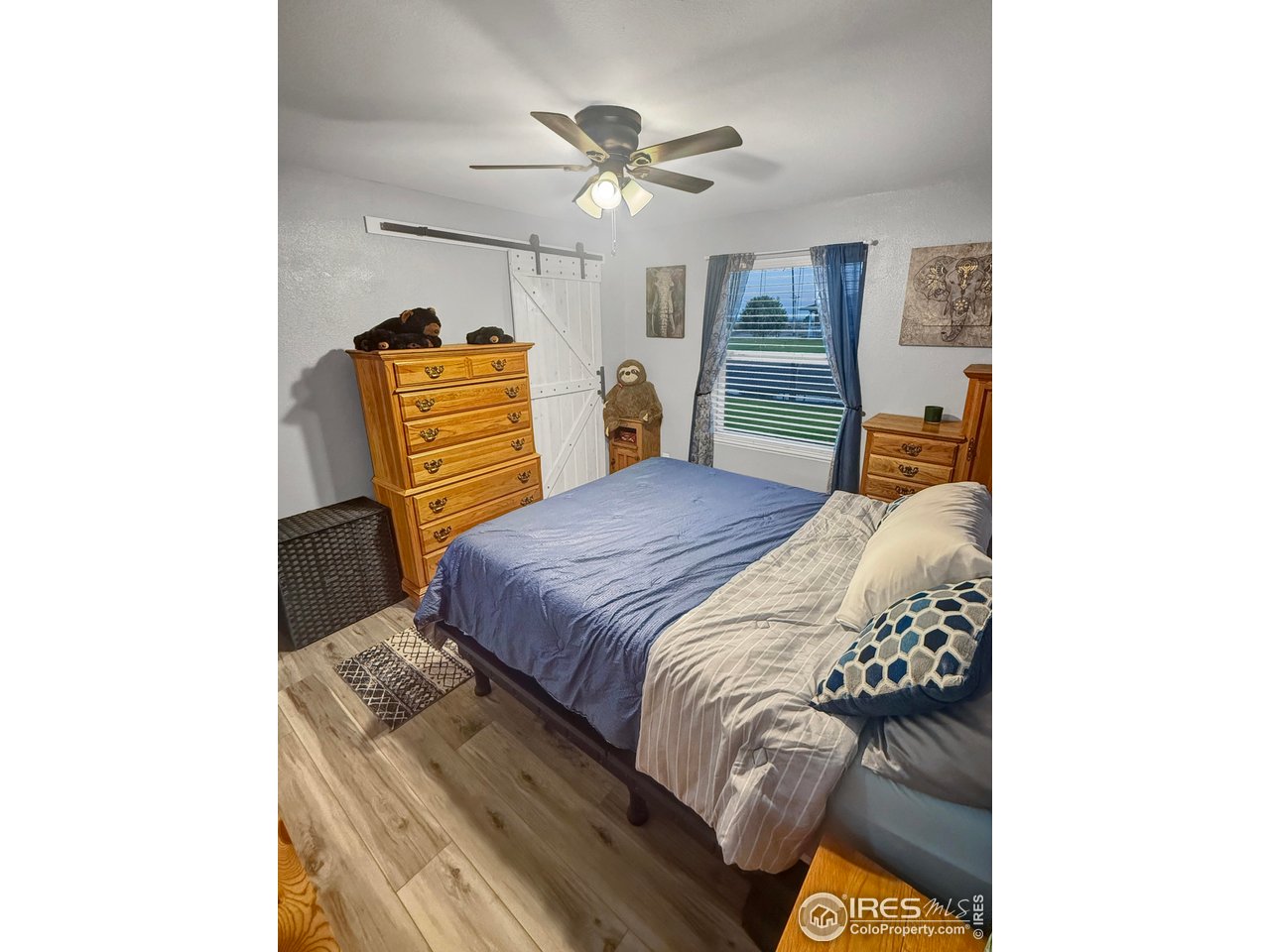 14971 Bluestem Street Sterling, CO 80751 - Photo 21 of 33 a bedroom with a bed and a chandelier
