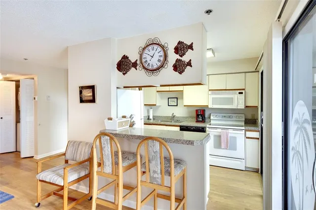 a kitchen with stainless steel appliances granite countertop a stove a refrigerator and a refrigerator with wooden floor