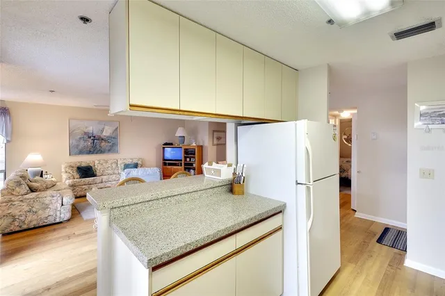 a kitchen with a refrigerator a stove and a wooden floor