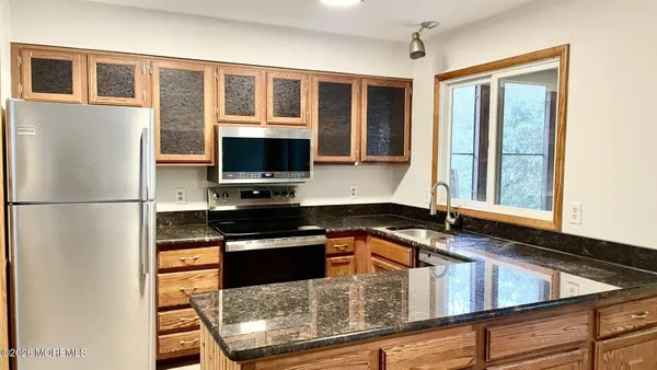 a kitchen with stainless steel appliances granite countertop a refrigerator and a stove top oven