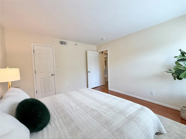 a bedroom with a bed and a potted plant