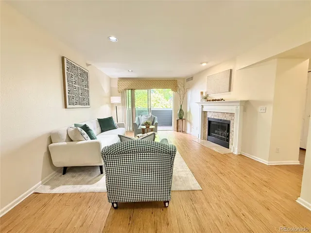 a living room with furniture a fireplace and a wooden floor
