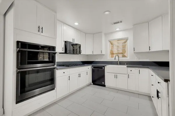 a kitchen with granite countertop white cabinets white stainless steel appliances with a sink and dishwasher