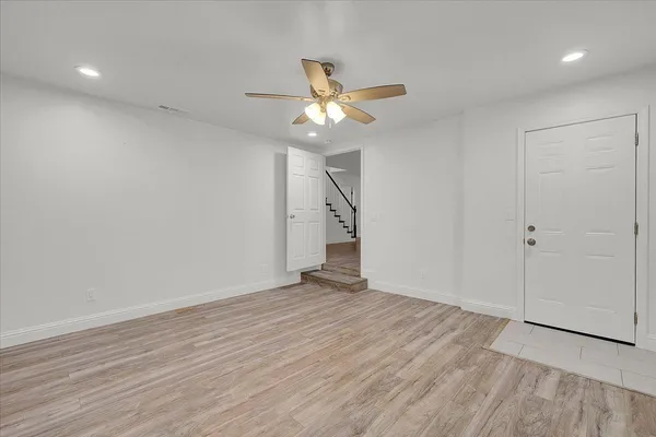 wooden floor in an empty room with a fan